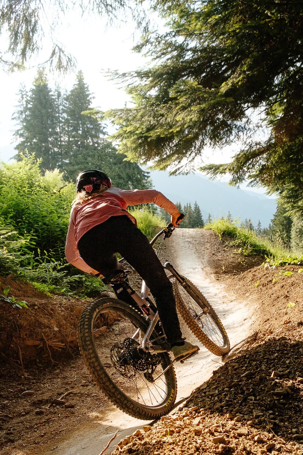 Maillot VTT femme manches longues terracotta Maillot VTT femme manches longues terracotta en action de dos en forêt