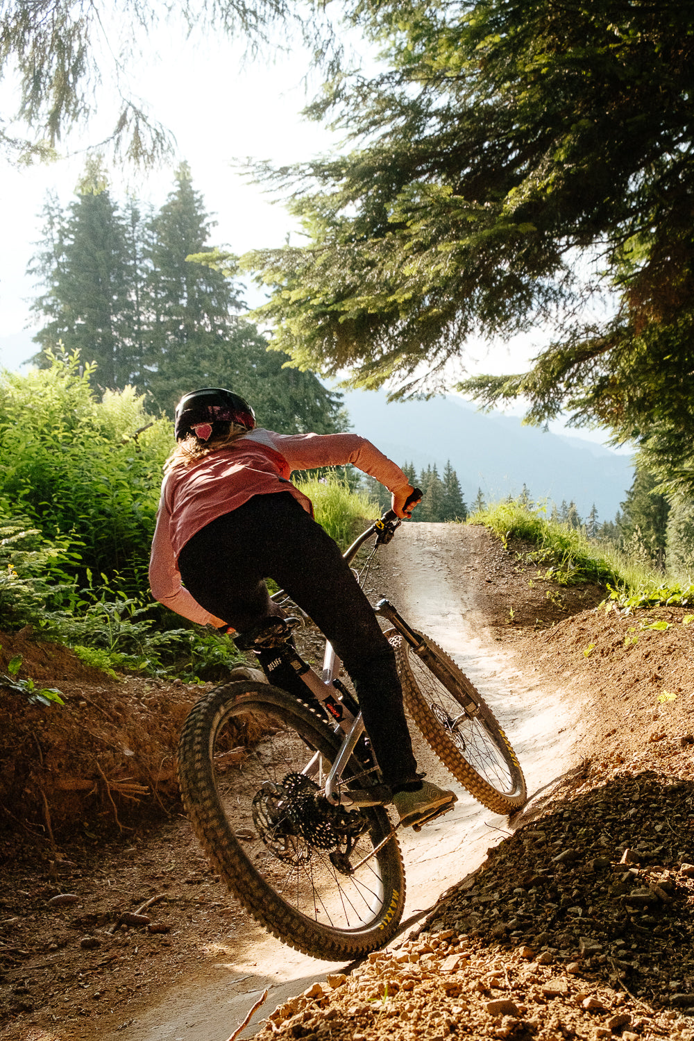 Maillot VTT femme manches longues terracotta Maillot VTT femme manches longues terracotta en action de dos en forêt